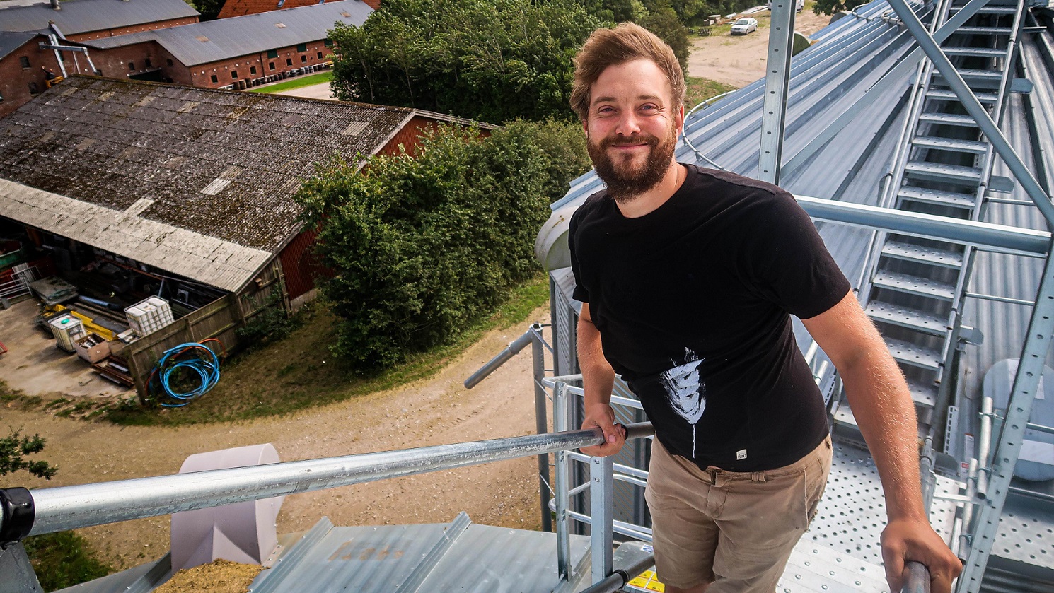 Andreas Poulsen står smilende på toppen af en silo
