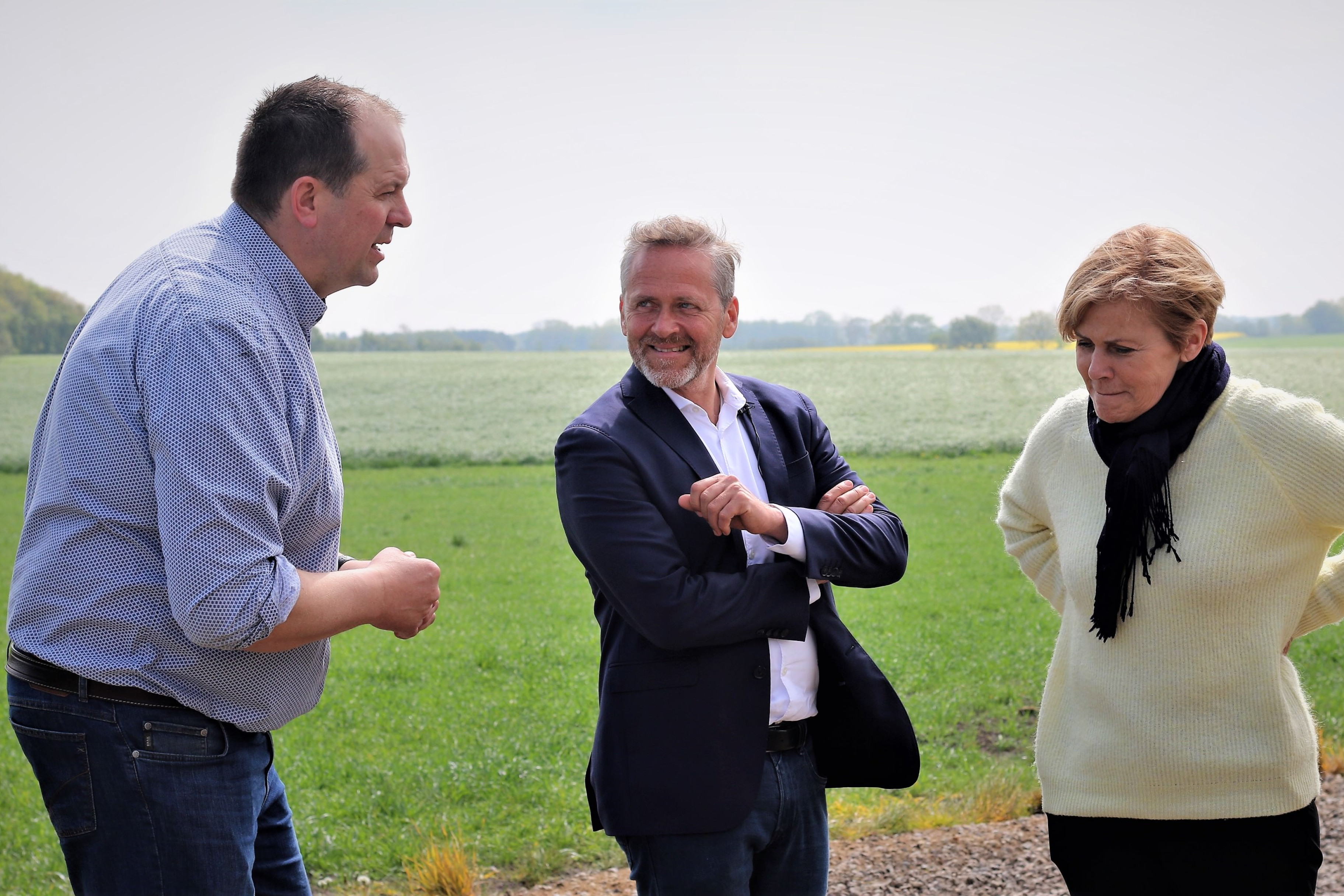 Mælkeproducent Christian Lund, Anders Samuelsen og Mette Bock står på Christian Lunds bedrift og snakker