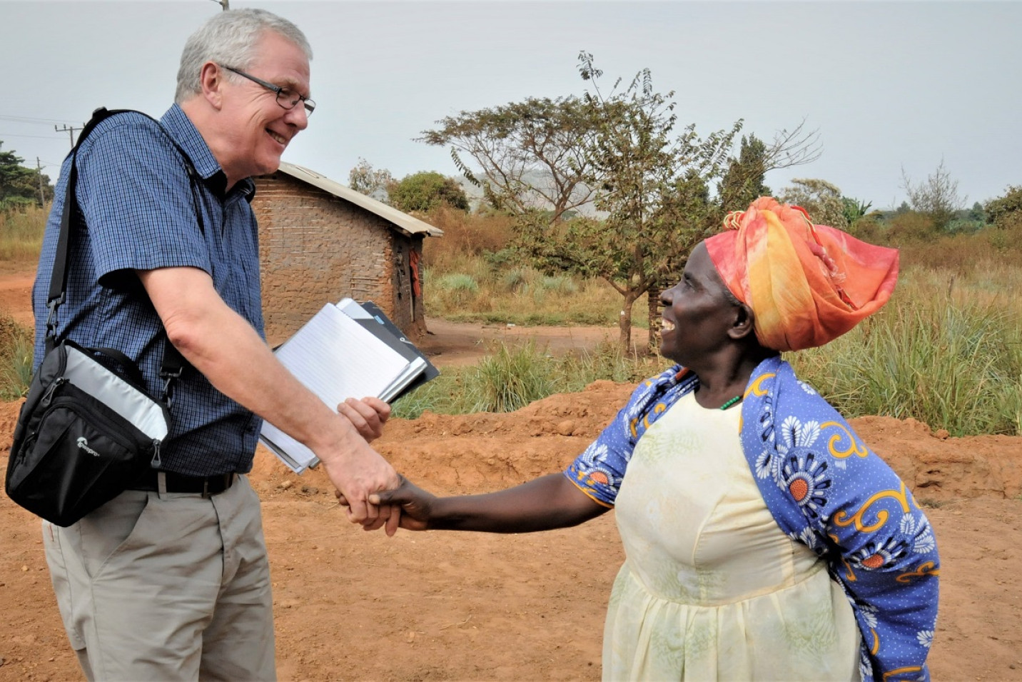 Per Rasmussen giver hånd til en kvinde i Uganda
