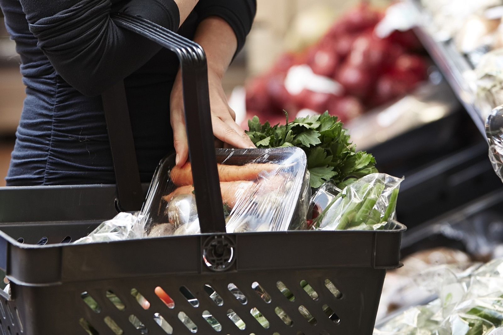 Kunde stopper grøntsager i indkøbskurv